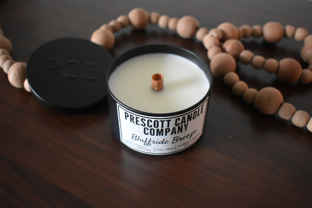 Candle from Prescott Candle Company on a wooden surface with beads