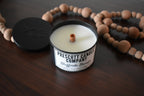 Candle from Prescott Candle Company on a wooden surface with beads